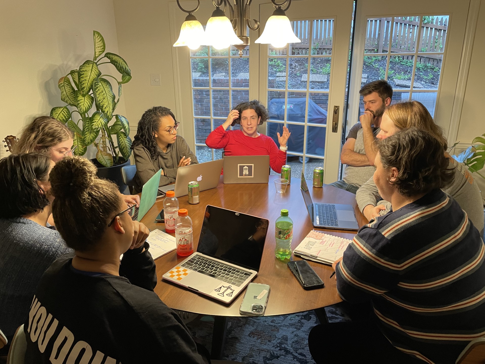 Photo of students and Professor Bach in a discussion around a kitchen table during the Spring 2022 Visions of Justice Practicum course.